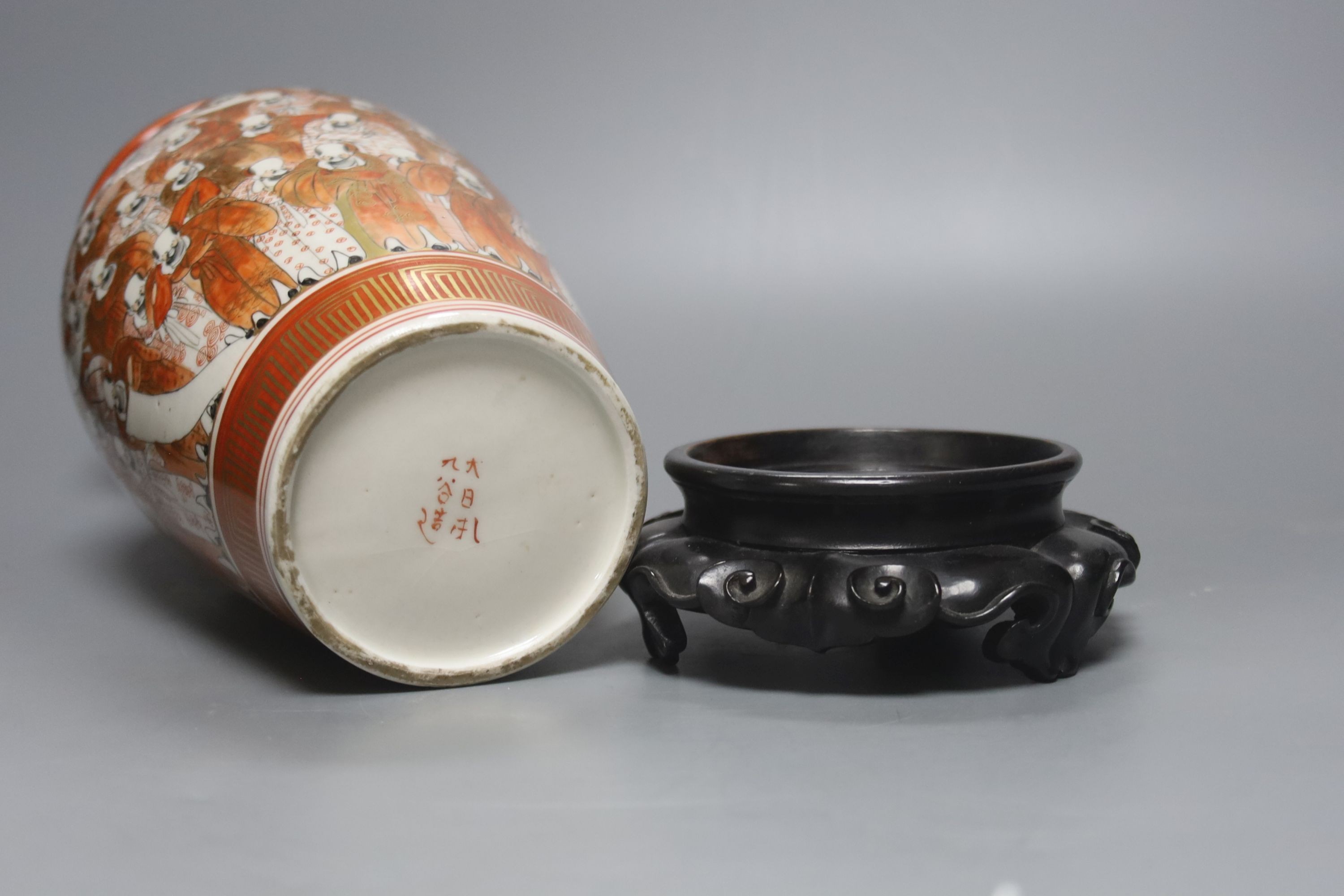 A tall Japanese Kutani porcelain vase, decorated with Rakan, 30cm, wood stand